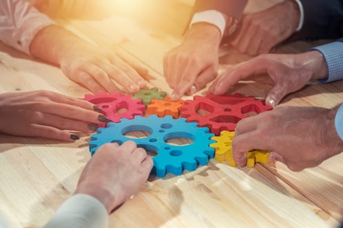 image d'illustration du travail collaboratif avec des mains assemblant ensemble plusieurs pièces de puzzle