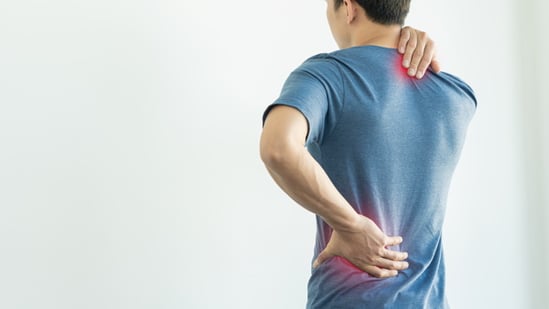 Photo d'une personne se tenant le bas du dos pour illustrer les maux de dos causés par la pénibilité au travail