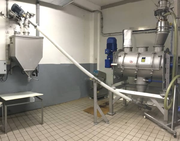 Atelier de préparation de mélanges de sel et d'épices pour salaison avec une vis transfert flexible sous le mélangeur vers poste de pesée
