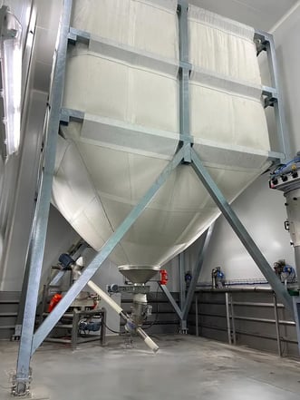 Silo souple en industrie alimentaire avec reprise par vis de transfert vers un tamiseur
