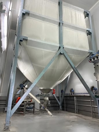 Silo souple en industrie alimentaire avec reprise par vis de transfert vers un tamiseur