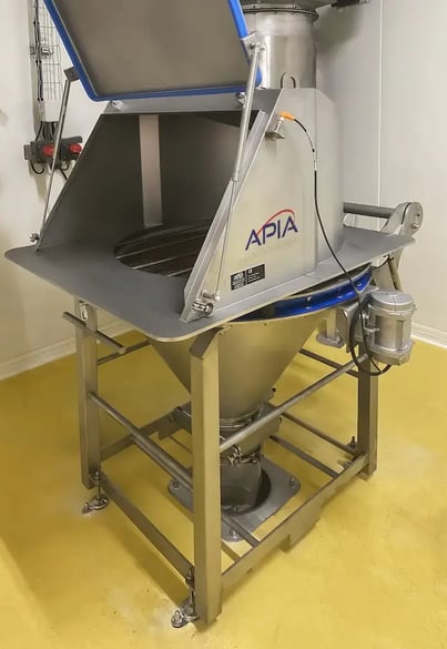 Poste vide-sacs installé chez IDS par APIA Technologie équipé d'une hotte de confinement et d'une grille vibrante de sécurité.