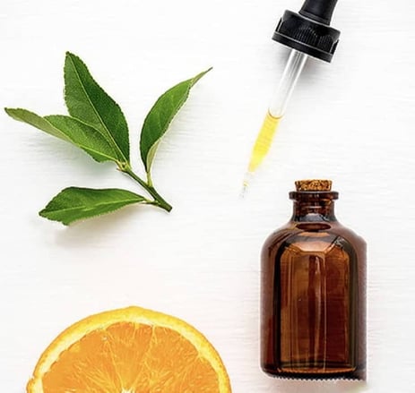 Image d'illustration d'extraction d'arôme naturel sucré ou salé avec une pipette, un flacon, des feuilles d'oranger et un demi orange