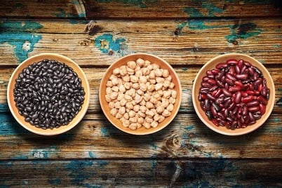 3 bols contenant des légumineuses : pois chiches, haricots noirs et haricots rouges