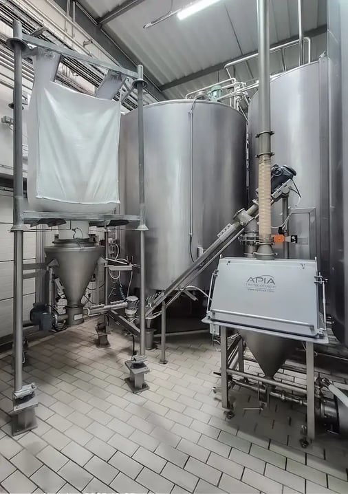 Atelier de poudrage chez Savoie Yaourt avec le réseau de transfert des poudres vers un mélangeur poudres-liquide conçu par APIA Technologie avec une videuse bigbag et un vide-sacs