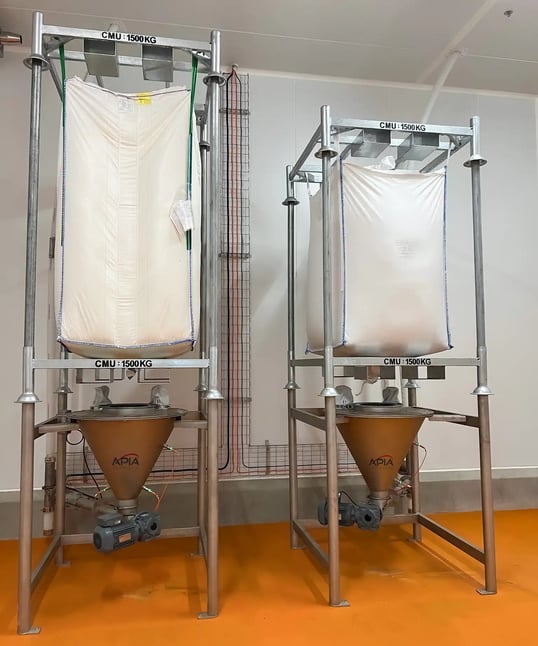Deux videuses bigbags avec trémies coniques installées par APIA Technologie et les départ des vis de transfert élévatrices vers les combles