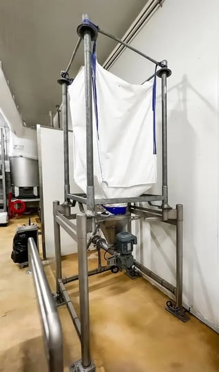 Déchargement d'un big-bag de sucre dans une zone de déconditionnement avant transfert vers bac Europe