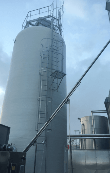 Transfert mécanique par vis souple de longue distance pour reprendre un stockage vrac de matière première alimentaire dans un silo extérieur