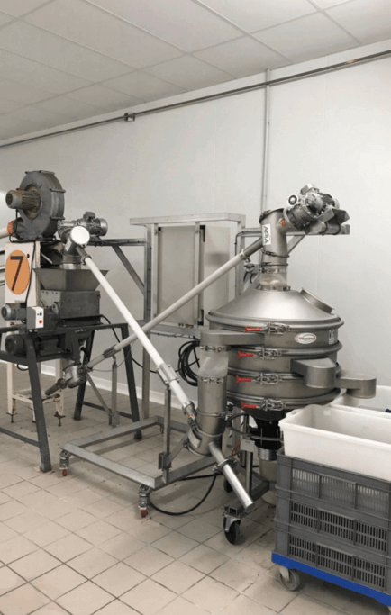 Reprise automatique de poudres alimentaires sous un tamiseur industriel avec recyclage de la matière mise au refus