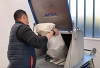 opérateur en train de vider un sac dans une trémie avec grille vibrante de sécurité