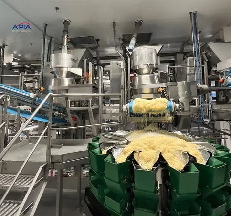 Zone de production de la Société Fromagère de Charchigné où l'on voit deux râpeuses alimentées en fécule par le transfert par vis flexible et d'où l'emmental râpé est acheminé vers les conditionneuses