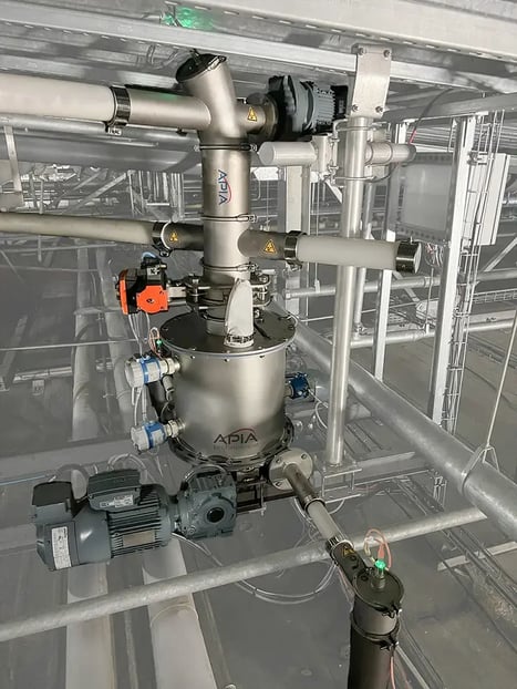 Doseur d'anti-mottant installé dans les combles par APIA Technologie et alimenté par une vis flexible. En dessous deux vis de distribution dosent la fécule vers les deux râpes