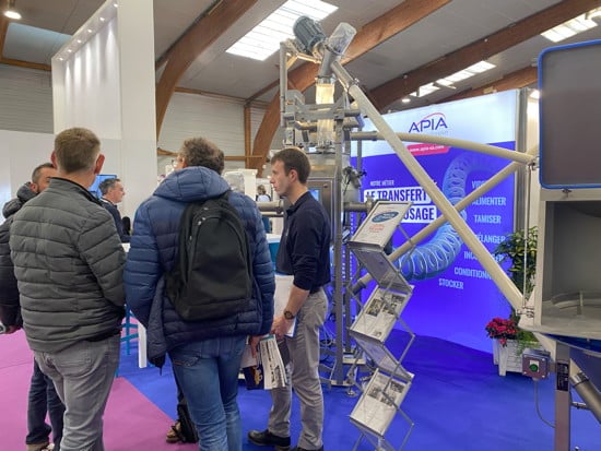 Vue du stand APIA technologie avec des visiteurs qui échangent avec un technico-commercial spécialiste du transfert des poudres