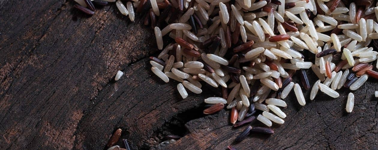 Zoom sur des grains de riz blancs et noirs sur une table en bois