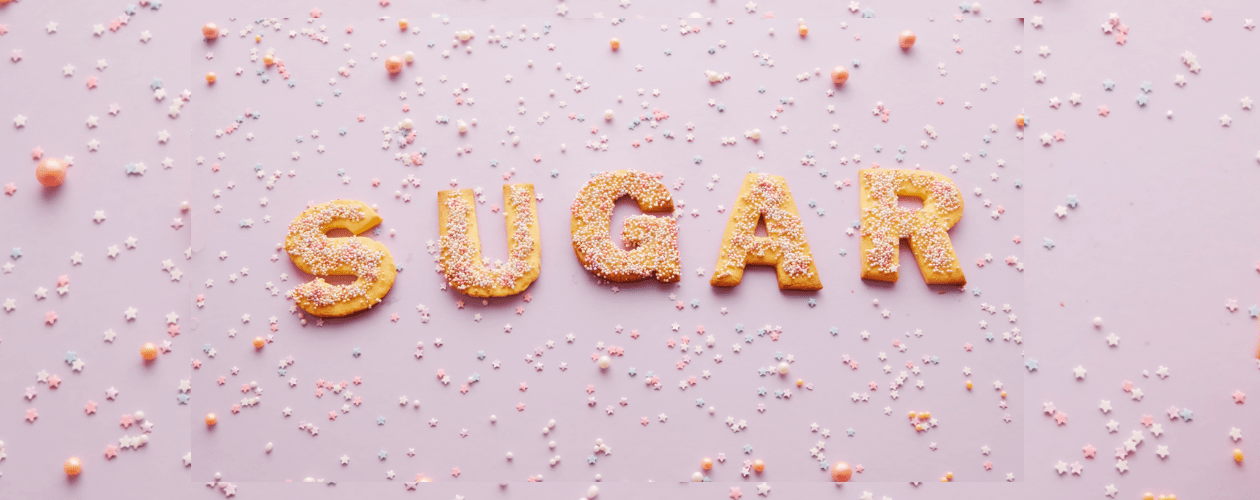 Image colorée représentant du sucre acidulé disposé sur des gâteaux formant le mot Sugar