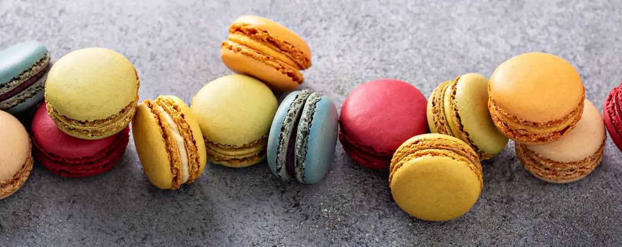 une farandole de macarons multicolores posée sur une table