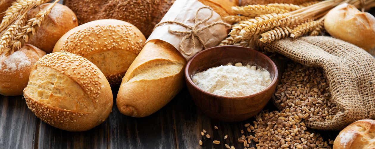 Sélection de pains artisanaux avec un bol de farine entrant dans leur composition